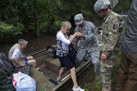 Members of the Louisiana Army National Guard rescue people from rising floodwater near Walker, La.