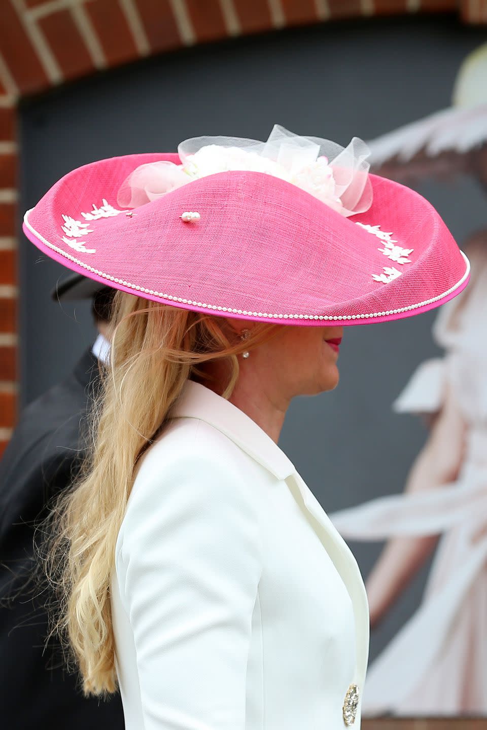 <p>A guest accessorized with a a hot pink linen hat with white lace appliques. </p>