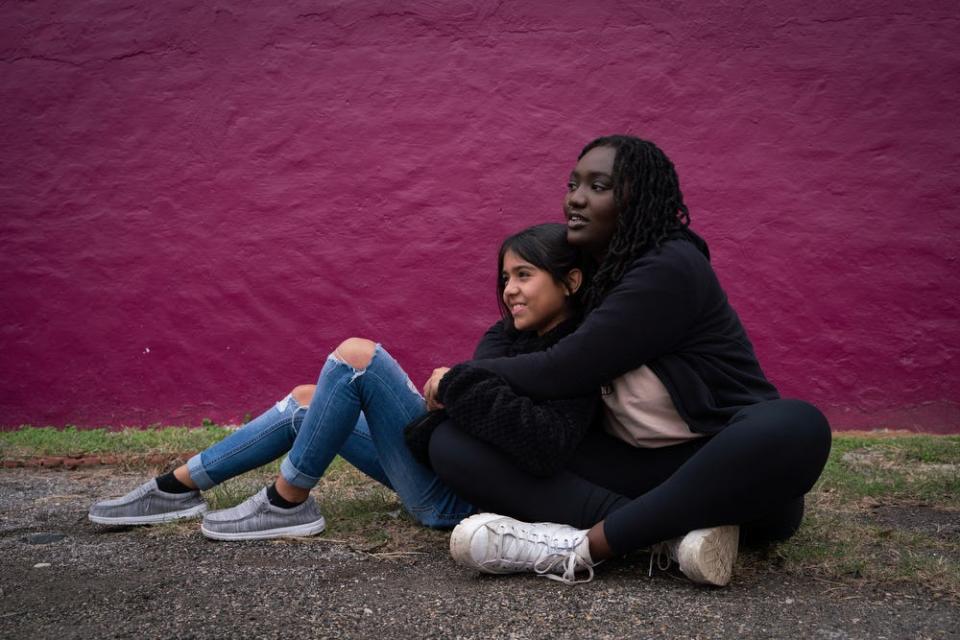 Caitlyne Gonzales, 10, of Uvalde, Texas, left, who survived the Robb Elementary School shooting on May 24, 2022, sits for a photo with Zoe Touray, 18, of Pontiac, Michigan, who survived the Oxford High School shooting on Nov. 30, 2021, in downtown Uvalde on Sunday, Nov. 20, 2022.