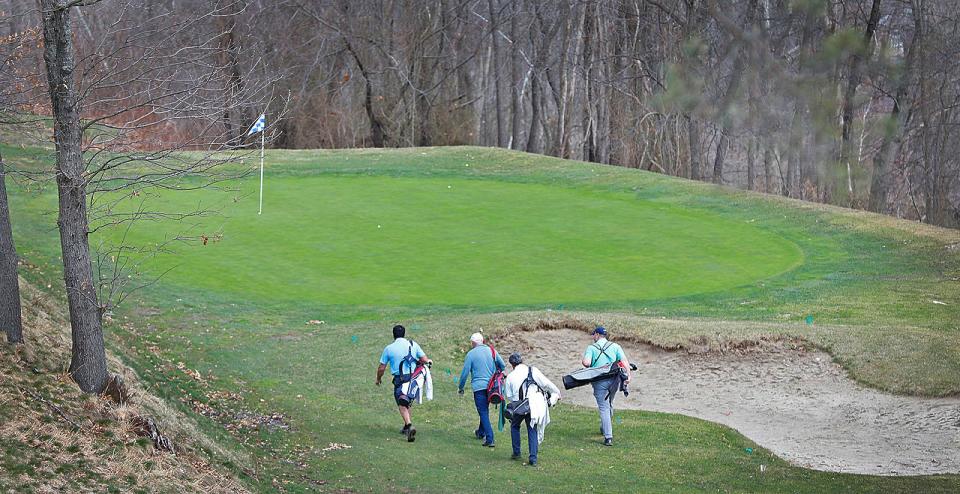 Golfers approach a green at Furnace Brook Golf Course in Quincy on Friday, March 25, 2022.