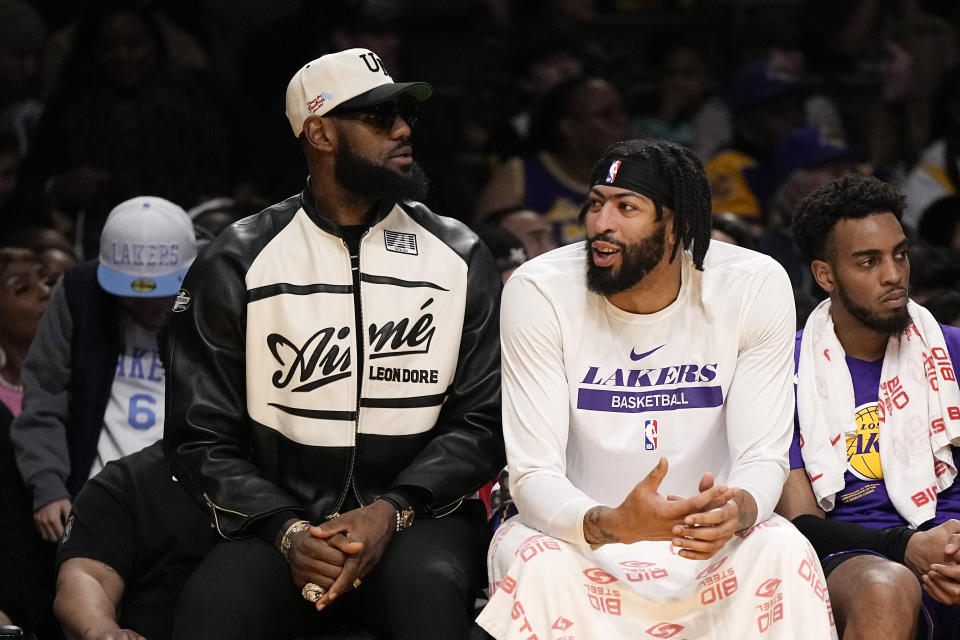 Los Angeles Lakers' LeBron James, left, and forward Anthony Davis chat as they sit on the bench during the first half of an NBA basketball game against the Oklahoma City Thunder Friday, March 24, 2023, in Los Angeles. (AP Photo/Mark J. Terrill)