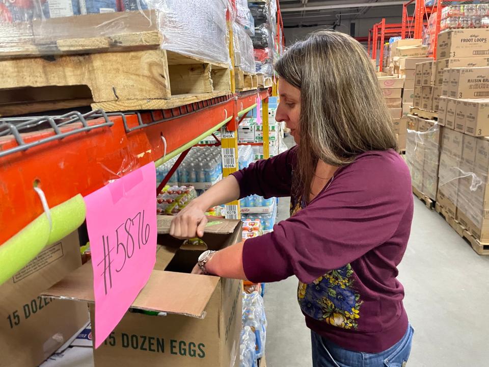 Annie Stockton, vice president of the Gemma E. Moran United Way/Labor Food Center in Groton, sorts goods in the warehouse. The food center has seen a 25% increase in need with the reduction of SNAP benefits to pre-pandemic levels in March.