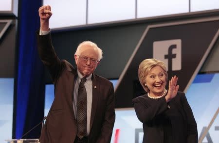 Democratic U.S. presidential candidates Senator Bernie Sanders and Hillary Clinton wave before the start of the Univision News and Washington Post Democratic U.S. presidential candidates debate in Kendall, Florida March 9, 2016. REUTERS/Javier Galeano