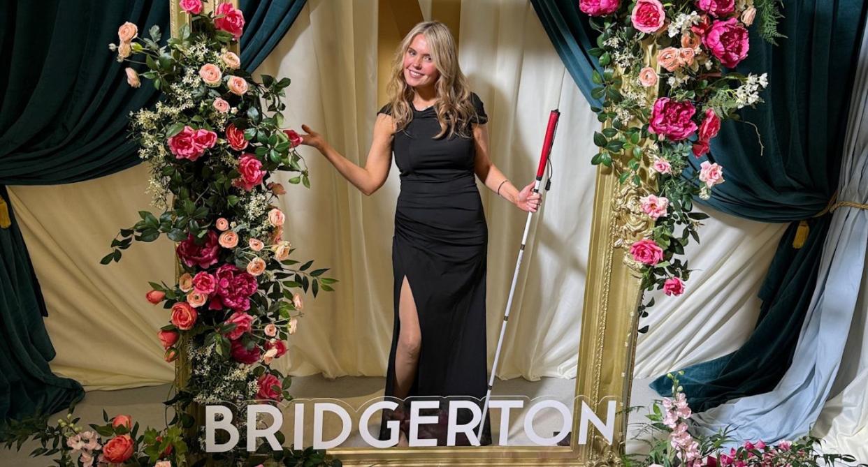 Claire Sisk in a black dress with cane posing in a Bridgerton display. (Supplied)