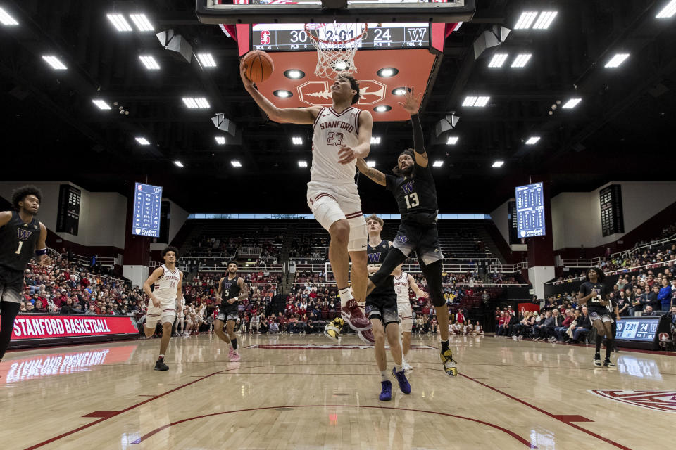 Stanford forward Brandon Angel (23) lays up the ball in front of Washington forward Langston Wilson (13) during the first half of an NCAA college basketball game in Stanford, Calif., Sunday, Feb. 26, 2023. (AP Photo/John Hefti)