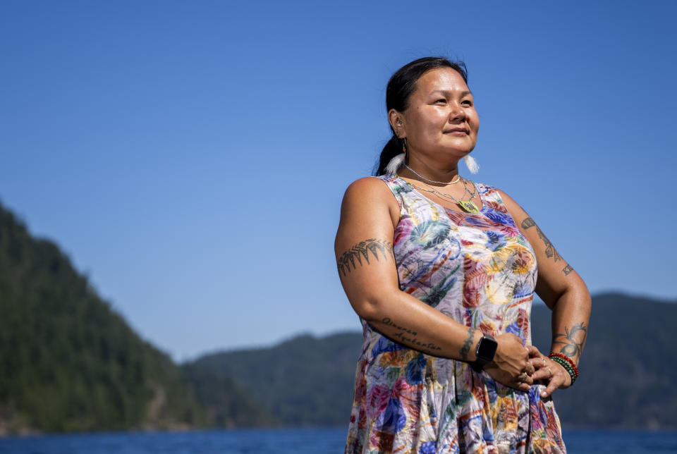 Jeanette Kiokun, the tribal clerk for the Qutekcak Native Tribe in Seward, Alaska, poses for a portrait on the shore of Lake Crescent at NatureBridge in the Olympic National Park during the 2023 Tribal Climate Camp, Thursday, Aug. 17, 2023, near Port Angeles, Wash. Participants representing at least 28 tribes and intertribal organizations gathered to connect and share knowledge as they work to adapt to climate change that disproportionally affects Indigenous communities. More than 70 tribes have taken part in the camps that have been held across the United States since 2016. (AP Photo/Lindsey Wasson)