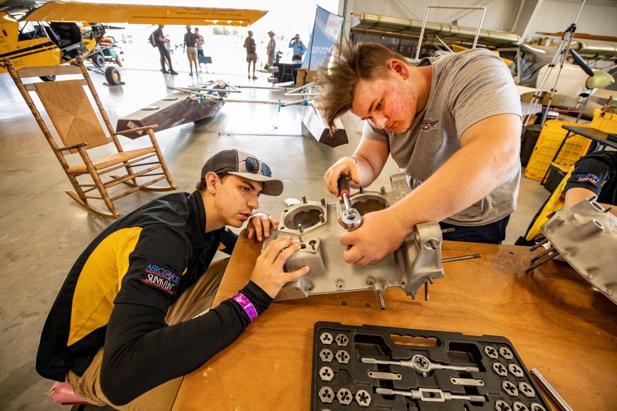 Caleb Brock, left, and Weston Dudley from McKinney, Texas, work on an aircraft engine in the Lakeland Aero Club hangar at the 49th annual Sun 'n Fun Aerospace Expo at Lakeland Linder Airport on Tuesday. The Tango Thirty One Aero Clube from McKinney was formed after Kevin Lacey came to Lakeland and met the Lakeland Aero Club president, Mike Zidziunas