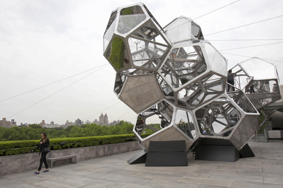 People visit a structure by Tomas Saraceno called "Cloud City" during a media preview on the rooftop of the Metropolitan Museum of Art in New York, Monday, May 14, 2012. The maker of Cloud City, Argentine artist Tomas Saraceno, wants to provoke the feeling of being in a cloud floating in the middle of several realities. (AP Photo/Seth Wenig)