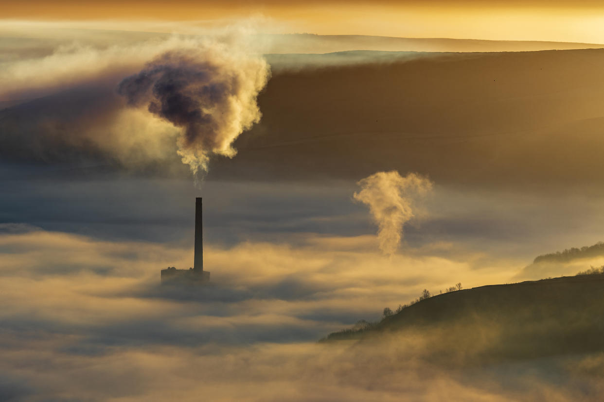 Hope valley and Castleton on a stunning misty morning with the pollution of the local cement factory.  Peak District National park. Derbyshire.