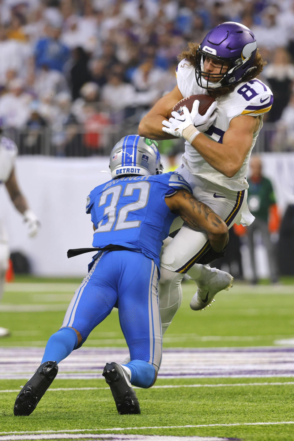 Minnesota Vikings tight end T.J. Hockenson (87) catches a pass over Detroit Lions safety Brian Branch (32) during the first half of an NFL football game, Sunday, Dec. 24, 2023, in Minneapolis. (AP Photo/Bruce Kluckhohn)