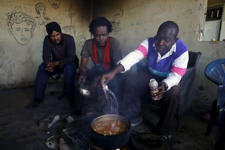 Sudanese immigrants cook food in their shelter in the western Greek town of Patras May 4, 2015. REUTERS/Yannis Behrakis