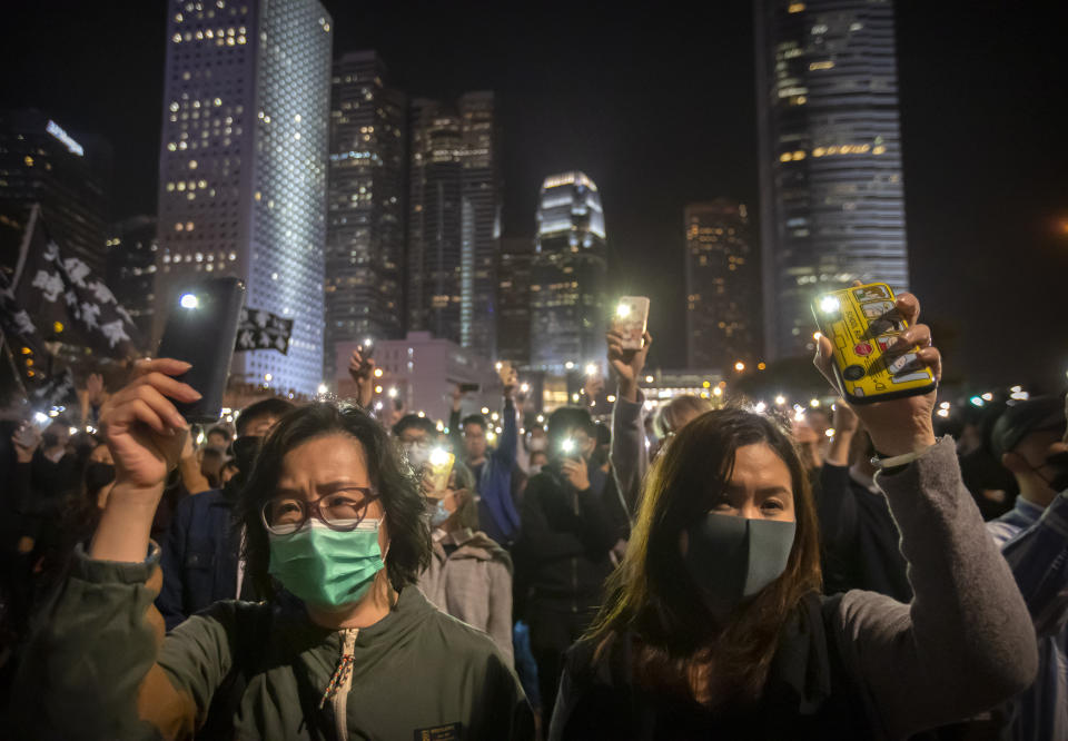 Protestors hold up their smartphone lights at a rally in Hong Kong, Thursday, Dec. 12, 2019. Protesters in Hong Kong have written hundreds of Christmas cards for detainees jailed in the city's pro-democracy movement. At a rally on Thursday night, protesters promised on the cards that detainees won't be forgotten as they face spending the festive season behind bars. (AP Photo/Mark Schiefelbein)