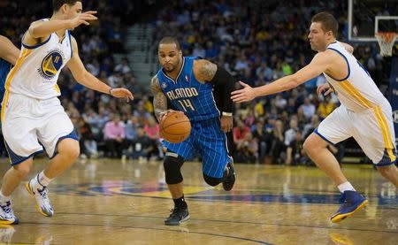 Orlando Magic guard Jameer Nelson (14) drives in between Golden State Warriors guard Klay Thompson (11) and forward David Lee (10) during the second quarter at Oracle Arena. Mar 18, 2014; Oakland, CA, USA; Kelley L Cox-USA TODAY Sports -