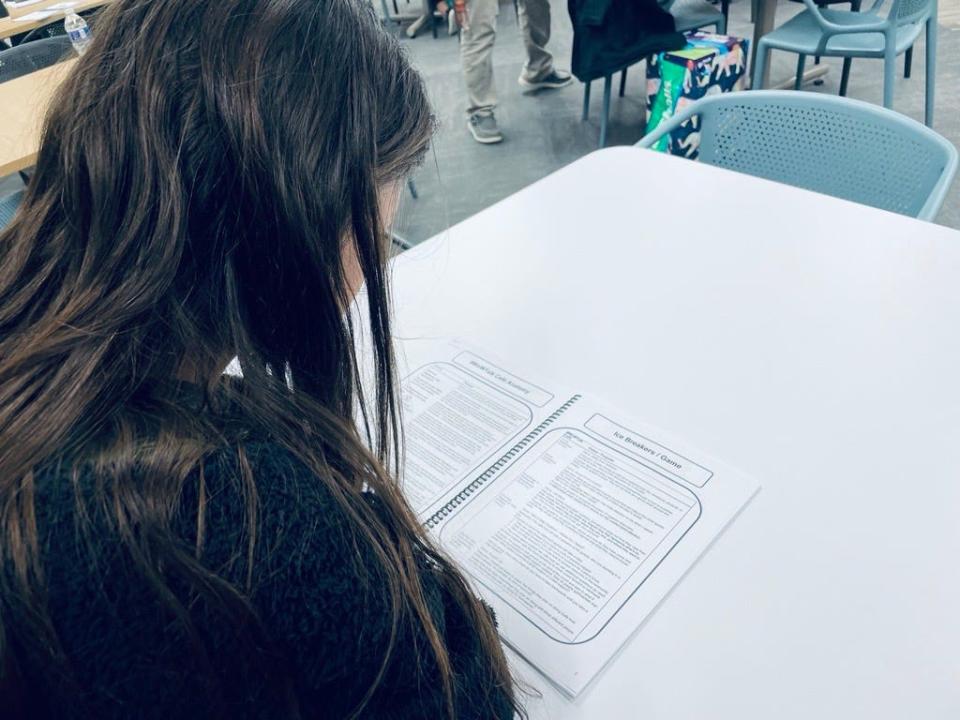 A young participate at a Teen Café aimed at helping middle- and high-school students through depression and mental health issues reviews material provided during a session.