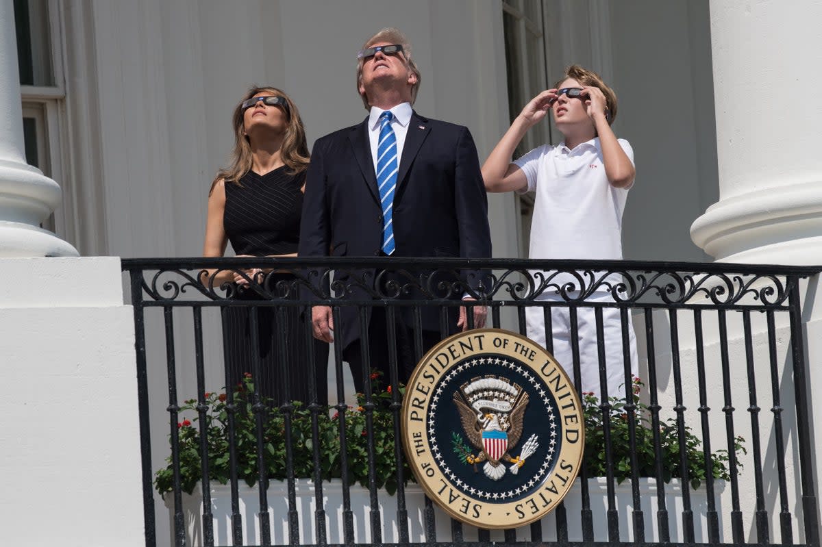 A young Barron Trump joins his parents on the White House balcony to observe a solar eclipse on 21 August 2017 (AFP/Getty)