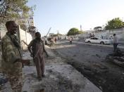 Soldiers assess the aftermath at the scene of an explosion outside Jazira hotel in Mogadishu, January 2, 2014. Three bombs exploded within an hour outside the hotel in a heavily fortified district of the Somali capital on Wednesday, killing at least 11 people. (REUTERS/Omar Faruk)