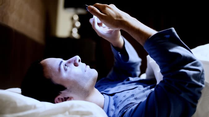 Man using his mobile phone in bed