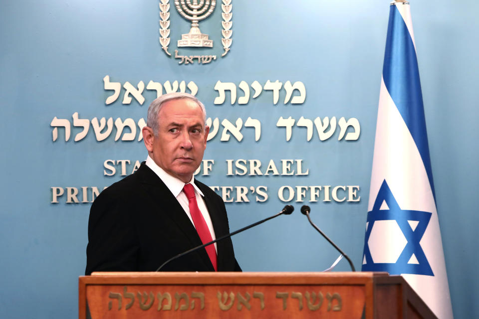 Prime Minister Benjamin Netanyahu approaches the podium to speak from his Jerusalem office on Saturday, March 14, 2020, saying Israel's restaurants and places of entertainment will be closed to stop the spread of the coronavirus. He also encouraged people not to go to their workplaces unless absolutely necessary. (Gali Tibbon/Pool via AP)