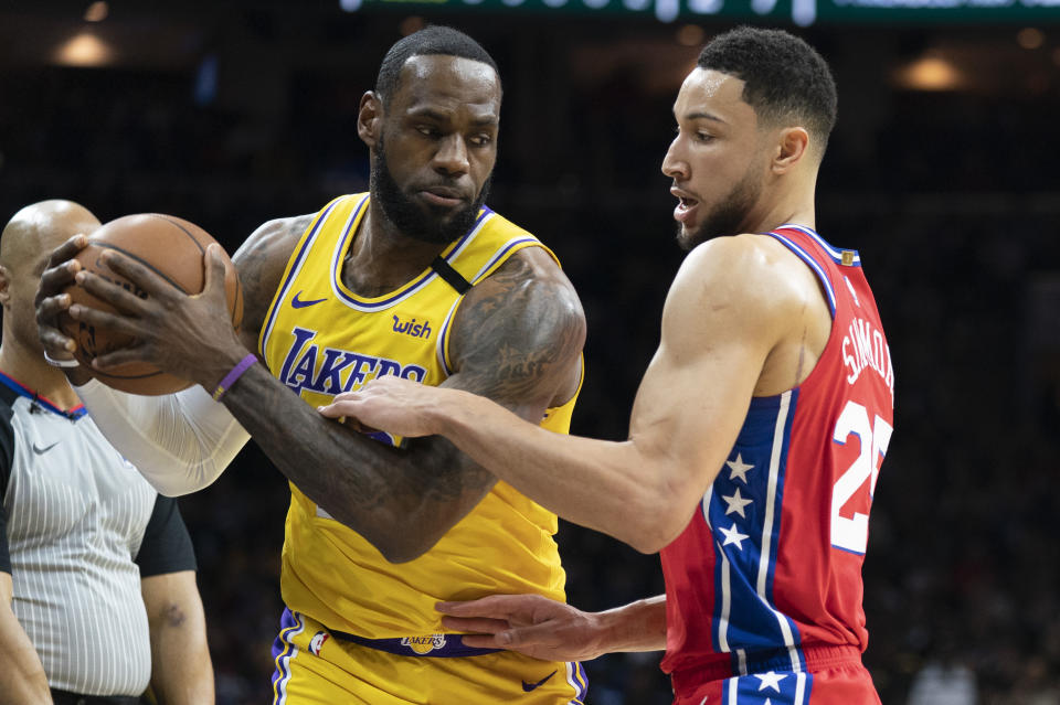 Los Angeles Lakers' LeBron James, left, tries to make his move on Philadelphia 76ers' Ben Simmons, right, during the first half of an NBA basketball game, Saturday, Jan. 25, 2020, in Philadelphia. (AP Photo/Chris Szagola)