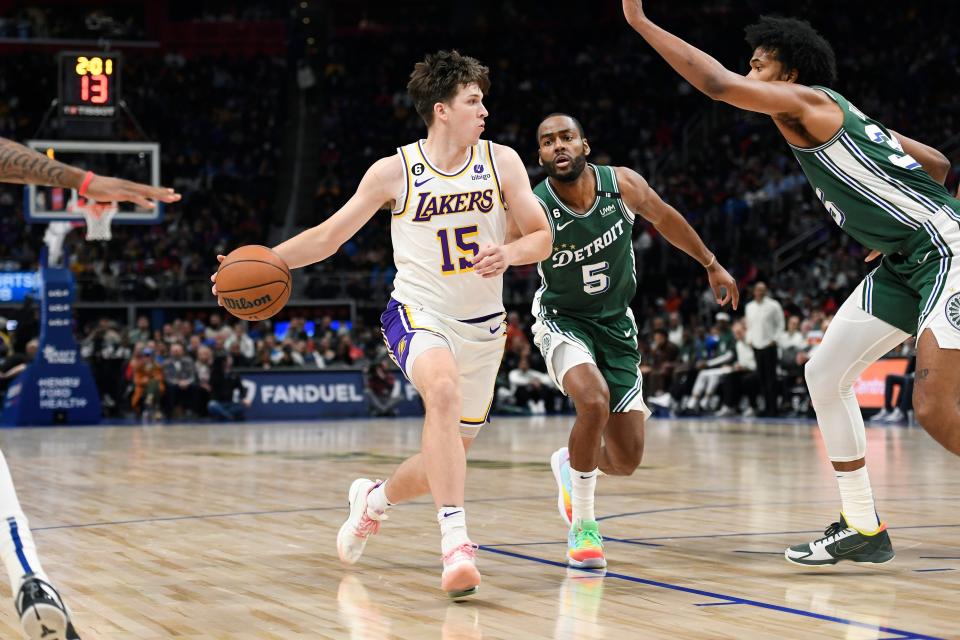 Los Angeles Lakers guard Austin Reaves, left, tries to get past Detroit Pistons guard Alec Burks, middle, and forward Marvin Bagley III during the second half of an NBA basketball game, Sunday, Dec. 11, 2022, in Detroit.