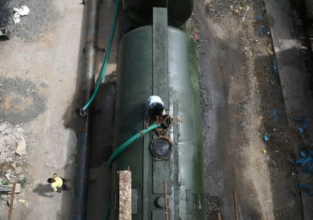 A worker fills a tanker train with water, which will be transported and supplied to drought-hit city of Chennai, at Jolarpettai railway station in the southern state of Tamil Nadu