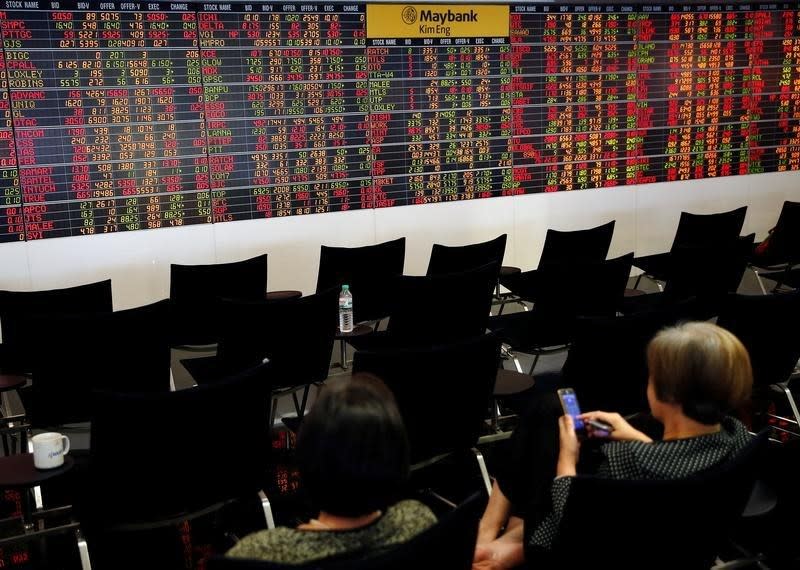 People monitor a stock index board at a bank in Bangkok, Thailand October 17, 2016. REUTERS/Edgar Su