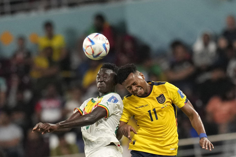 Senegal's Pape Gueye, left, and Ecuador's Michael Estrada go for a header during the World Cup group A soccer match between Ecuador and Senegal, at the Khalifa International Stadium in Doha, Qatar, Tuesday, Nov. 29, 2022. (AP Photo/Themba Hadebe)