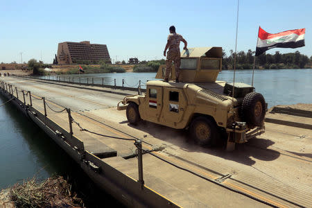 A new floating bridge installed by Iraqi military engineers that reconnects two halves of Mosul is seen in the Hawi al-Kaneesa area, south of Mosul, Iraq May 24, 2017. REUTERS/Alaa Al-Marjani