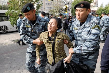 Kazakh law enforcement officers detain a woman during a rally held by opposition supporters in Nur-Sultan