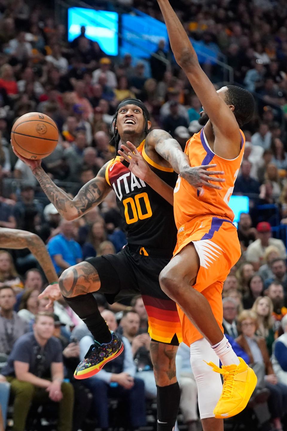 Phoenix Suns forward Mikal Bridges, right, defends against Utah Jazz guard Jordan Clarkson (00) during the first half of an NBA basketball game Friday, April 8, 2022, in Salt Lake City. (AP Photo/Rick Bowmer)