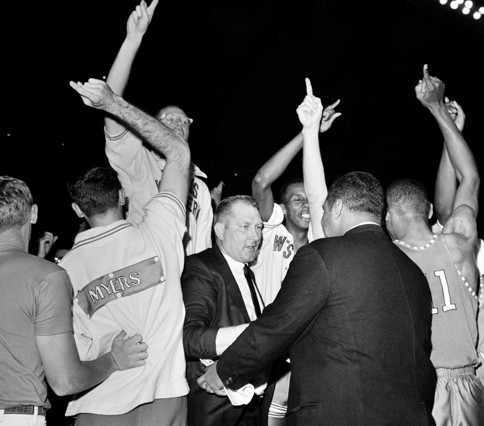 FILE - Don Haskins, center, coach of Texas Western, receives congratulations as his team is awarded the new National Collegiate Basketball championship in College Park, Md., March 19, 1966. (AP Photo/File)