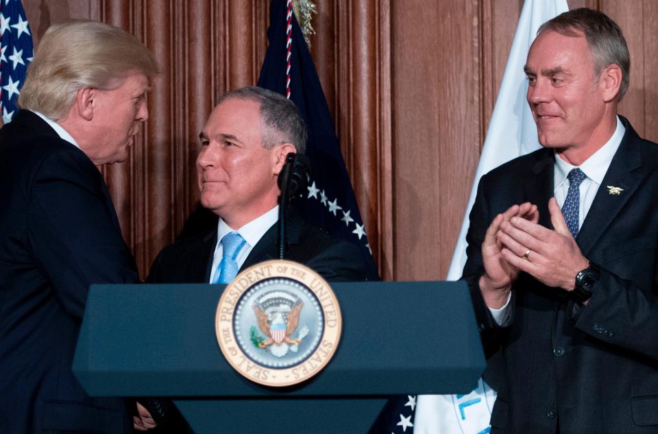 President Donald Trump shakes hands with Scott Pruitt before signing&nbsp;an executive order at the EPA's&nbsp;Washington, D.C., headquarters in March 2017. Zinke is at right. (Photo: JIM WATSON via Getty Images)