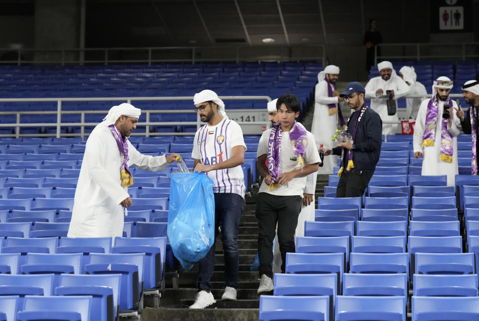Al Ain soccer fans pick up trash at the end of the first leg of the AFC Champions League final soccer match between Al Ain and Yokohama F. Marinos in Yokohama, Japan, Saturday, May 11, 2024. (AP Photo/Eugene Hoshiko)
