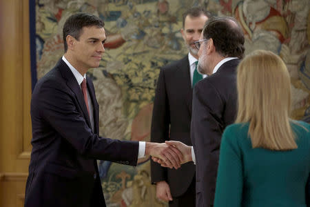 Spain's new Prime Minister and Socialist party (PSOE) leader Pedro Sanchez is greeted by ousted Prime Minister Mariano Rajoy as King Felipe looks on during a ceremony at the Zarzuela Palace in Madrid, Spain, June 2, 2018. Emilio Naranjo/Pool via REUTERS