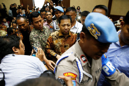 Policemen guard as former Indonesian parliament speaker Setya Novanto (C) walks to his trial at a courtroom in Jakarta, Indonesia, April 24, 2018. REUTERS/Beawiharta