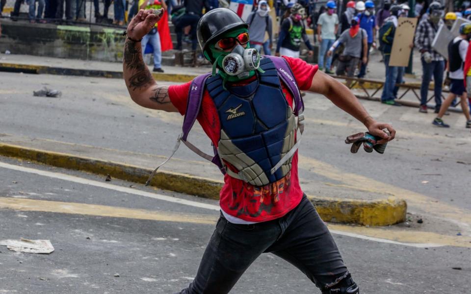 Opposition sympathizers clash with Venezuela security forces during a protest in Caracas - Credit: Cristian Hernandez/EPA