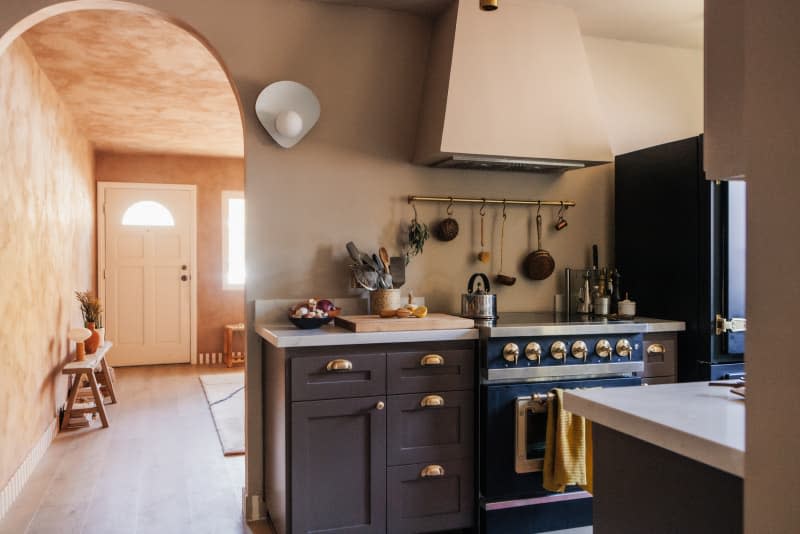 Beige kitchen with textured walls and deep blue cabinets and appliances