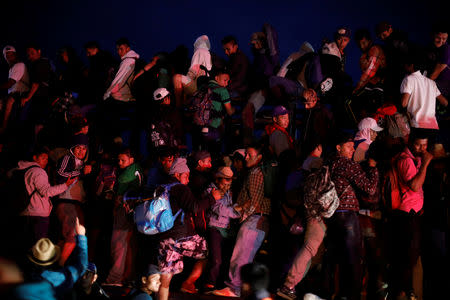 Migrants, part of a caravan traveling from Central America en route to the United States, ride in a truck after resting in a makeshift camp in Matias Romero Avendano, Mexico, November 10, 2018. REUTERS/Ueslei Marcelino