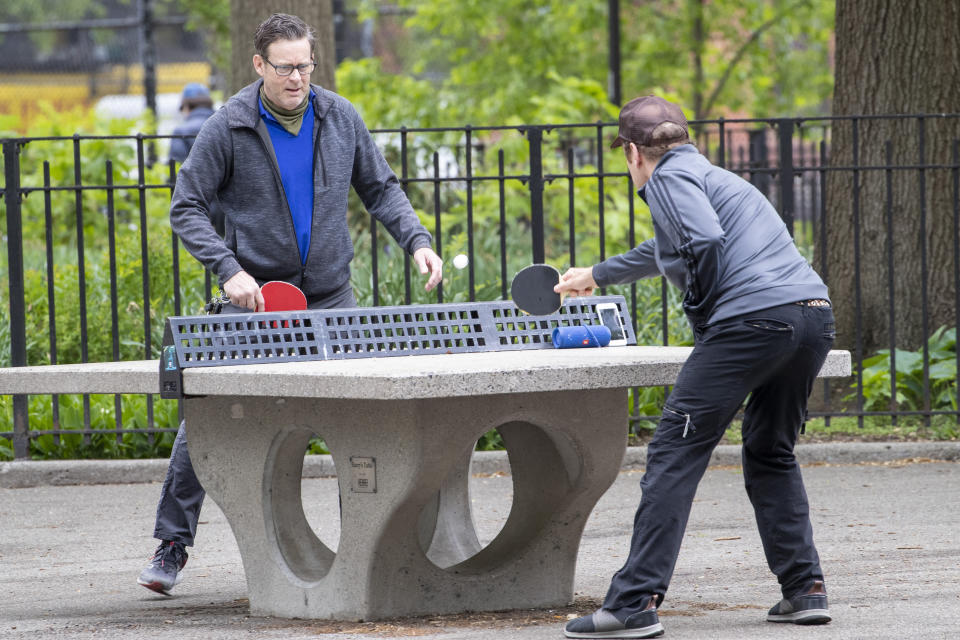 In this Monday, May 11, 2020 photo, men play ping pong without face masks at Tompkins Square Park in New York. New York's governor has ordered masks for anyone out in public who can't stay at least six feet away from other people. Yet, while the rule is clear, New Yorkers have adopted their own interpretation of exactly when masks are required, especially outdoors. (AP Photo/Mary Altaffer)