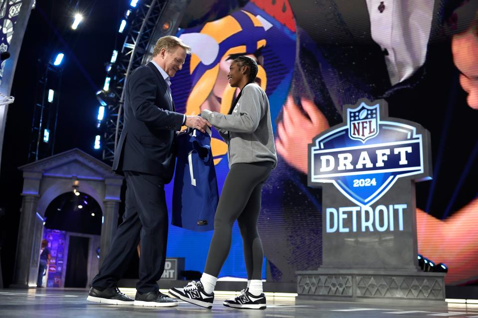 South Bend Riley junior Kayla Wright, right, presents the Indianapolis Colts first-round draft pick jersey to NFL Commissioner Roger Goodell during the NFL Draft Thursday, April 25, 2024, in Detroit.