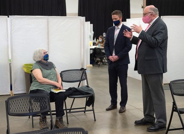 Corrie Watt, left, chats with Dr. Robert Strang, Nova Scotia's chief medical officer of health, right, and Premier Iain Rankin after receiving a COVID-19 vaccine at a clinic in Halifax on Friday, April 16, 2021.