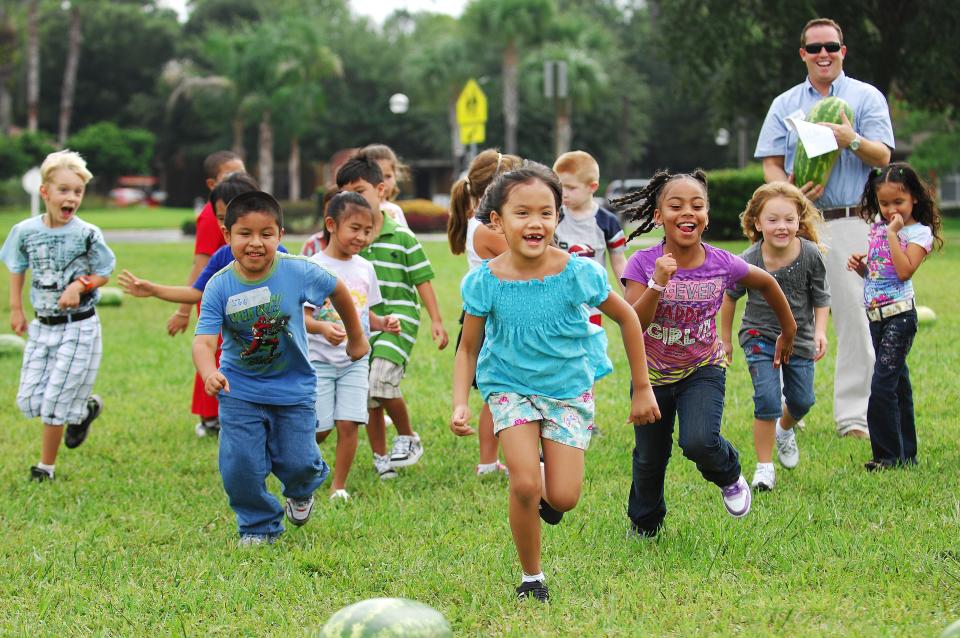 Kids in 2010 make a dash for slices of watermelon after learning a bit about the fruit from extension agent Brad Burbaugh (right) on the first day of classes at Chets Creek Elementary. The first day of school featured animals, tractors and seedlings to match that year's motto of "Cultivating a Community of Excellence!"