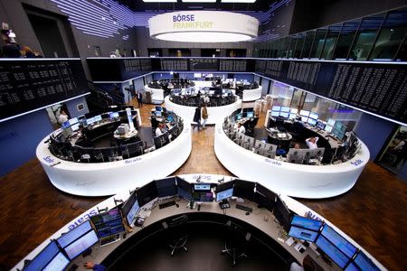 Traders work at their desks in front of the German share price index, DAX board, at the stock exchange in Frankfurt, Germany, March 1, 2017. REUTERS/Ralph Orlowski