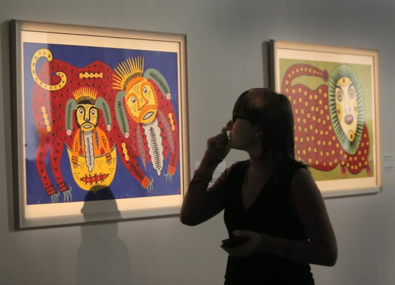 A visitor looks at painting by a Maria Prymachenko,