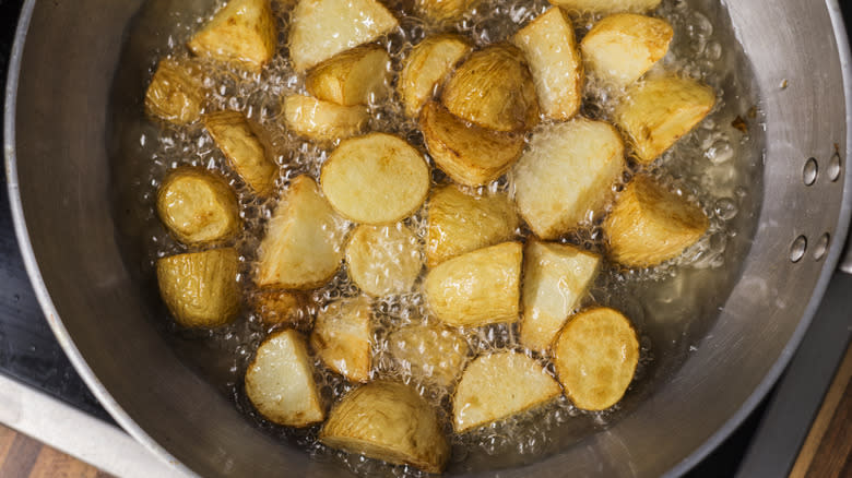 Potatoes frying in pan with oil