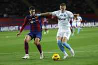 FILE -Barcelona's Andreas Christensen, left, and Girona's Artem Dovbyk challenge for the ball during the Spanish La Liga soccer match between Barcelona and Girona at the Olimpic Lluis Companys stadium in Barcelona, Spain, Sunday, Dec. 10, 2023. Bologna, Stuttgart and Girona are most strongly favored to be in the 36-team Champions League lineup when the lucrative format starts in September.(AP Photo/Joan Monfort, File)