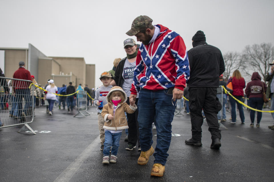 A man wearing a Confederate flag-themed sweatshirt walks with his children while queuing before President Donald Trump holds a rally on Oct. 26 in Lititz, Pennsylvania. (Photo: Mark Makela via Getty Images)