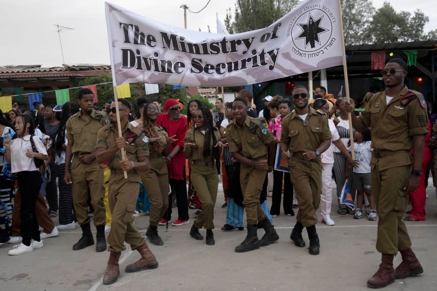 Members of the Hebrew Israelite community serving in the Israel Defence Forces dance during a procession honoring their service past their elders and community leaders during New World Passover celebrations marking the group’s exodus from the United States, in Dimona, Israel, Thursday, June 1, 2023. Community leaders say they send 100 percent of their eligible sons and daughters to Israeli national military service. (AP Photo/Maya Alleruzzo)