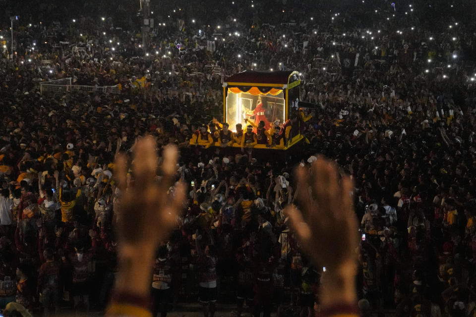Devotees raise their hands during the annual Black Nazarene procession which was resumed after a three-year suspension due to the coronavirus pandemic on Tuesday, Jan. 9, 2024 in Manila, Philippines. A mammoth crowd of mostly barefoot Catholic devotees joined a chaotic procession through downtown Manila Tuesday to venerate a centuries-old black statue of Jesus Christ with many praying for peace in the Middle East where Filipino relatives work. (AP Photo/Aaron Favila)
