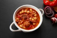 Callos a la madrileña ist ebenfalls ein klassisches Spanien-Gericht mit Kichererbsen. Das Rezept wurde in der Hauptstadt Madrid entwickelt. Der herzhafte Innereien-Eintopf wird oft mit Kutteln vom Rind in einem Schmortopf gegart - gemeinsam mit Chorizo- sowie Blutwurst, Zwiebel, Knoblauch und Tomaten. Dazu passt Muskatnuss, Pfeffer und Paprika - und natürlich ein gutes Glas Rotwein. (Bild: iStock/SGAFotoStudio)